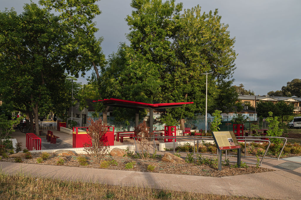Red shelter, seating and landscaped paths at Campbell Shopping Centre.