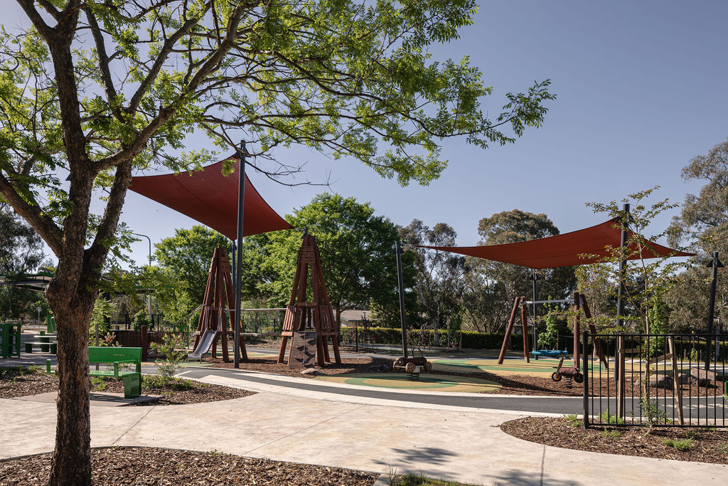 Duffy playground with shade sails and landscaped paths.